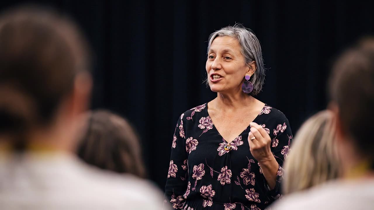 Leonie Sanderson speaking to an audience from the stage.