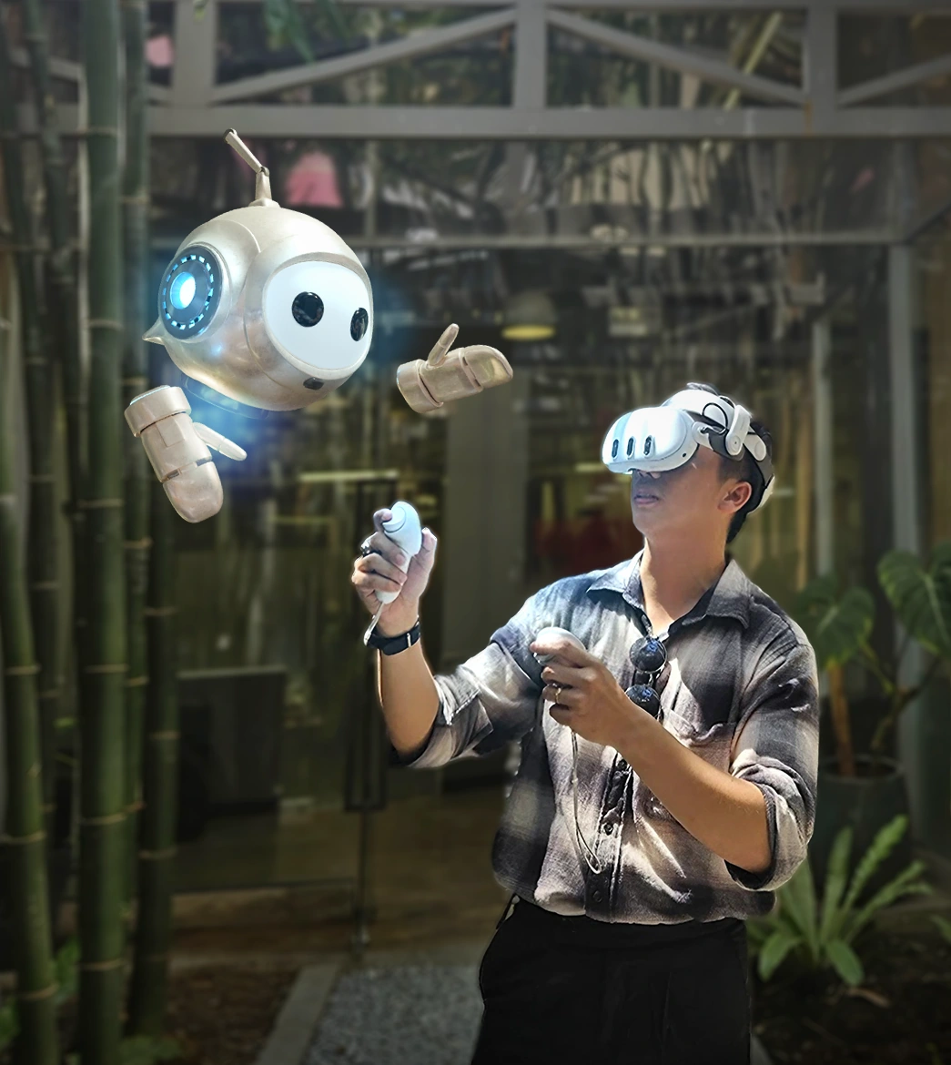 A man wearing a Meta Quest 3 headset raises two controllers while Peter, PTR's white and gold in-VR robot guide, floats beside him outdoors among bamboo and leafy plants