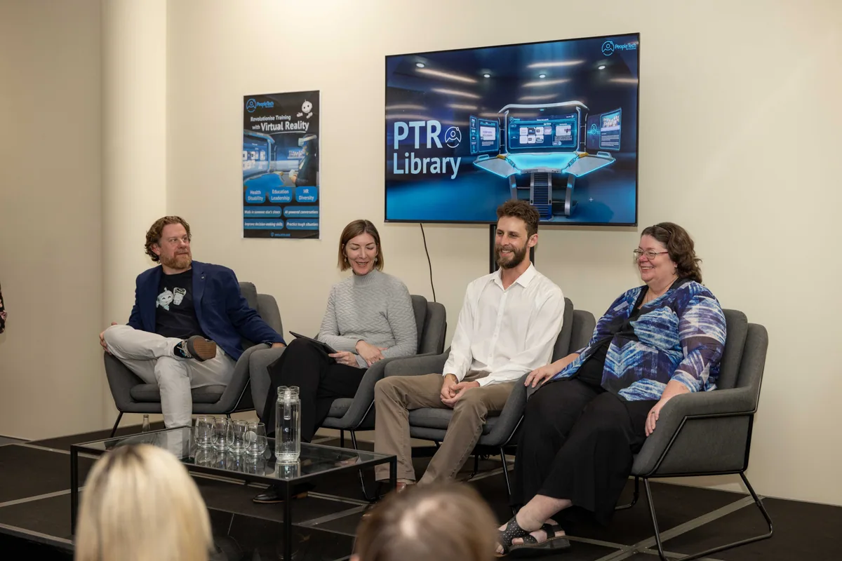 The full panel seated under the Library slide at the Townsville launch.