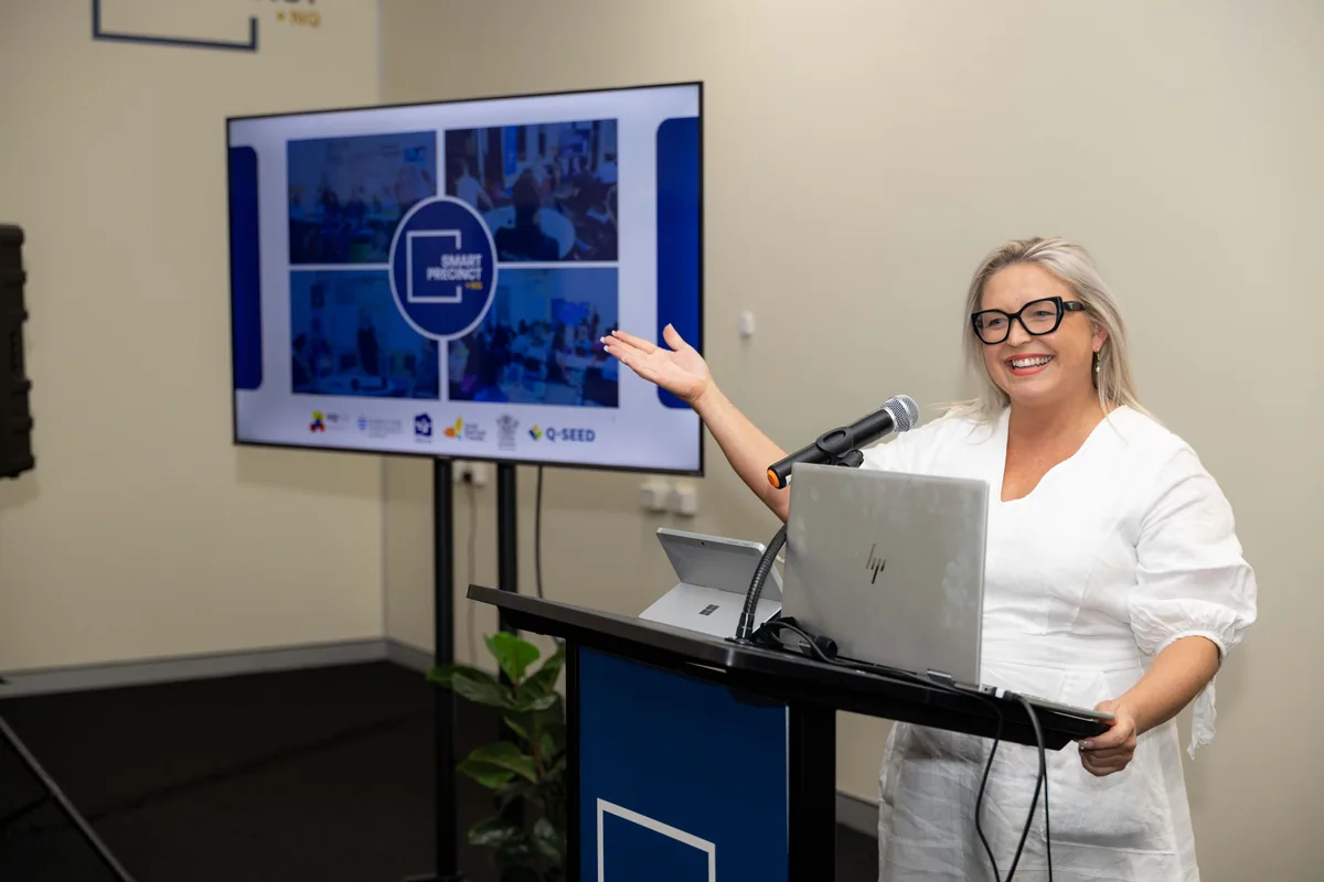 The host gestures to the screen during the welcome at the Townsville launch.