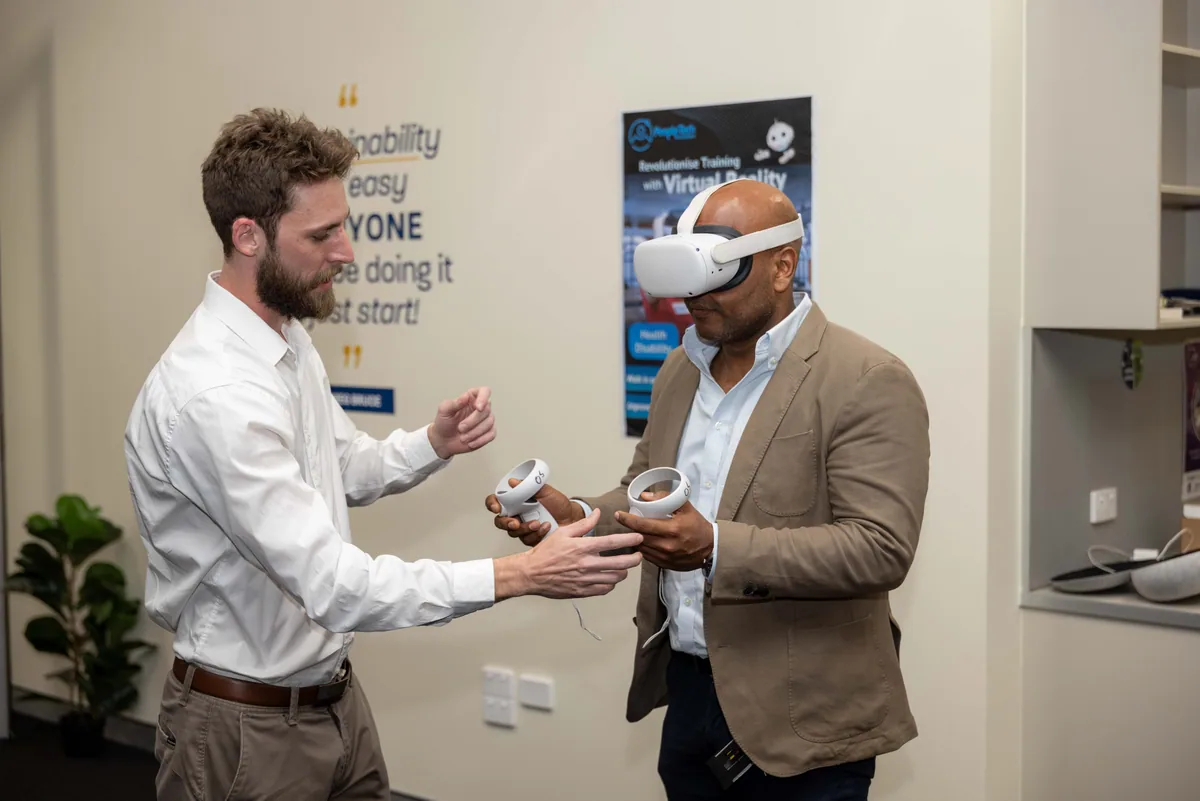 Passing the controllers to a guest. PTR VR Library public launch at Smart Precinct NQ, Townsville, 18 July 2024.