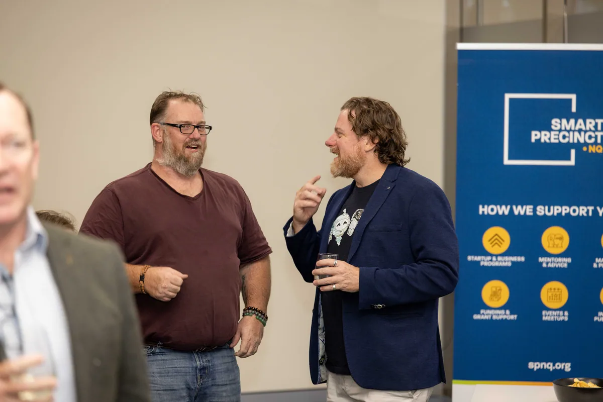Simon Lowe in conversation by the banner. PTR VR Library public launch at Smart Precinct NQ, Townsville, 18 July 2024.