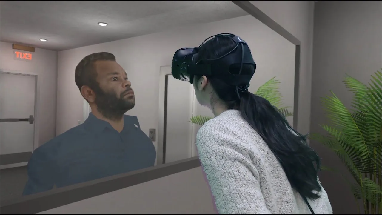 An older woman wearing a headset faces herself across a lounge room.