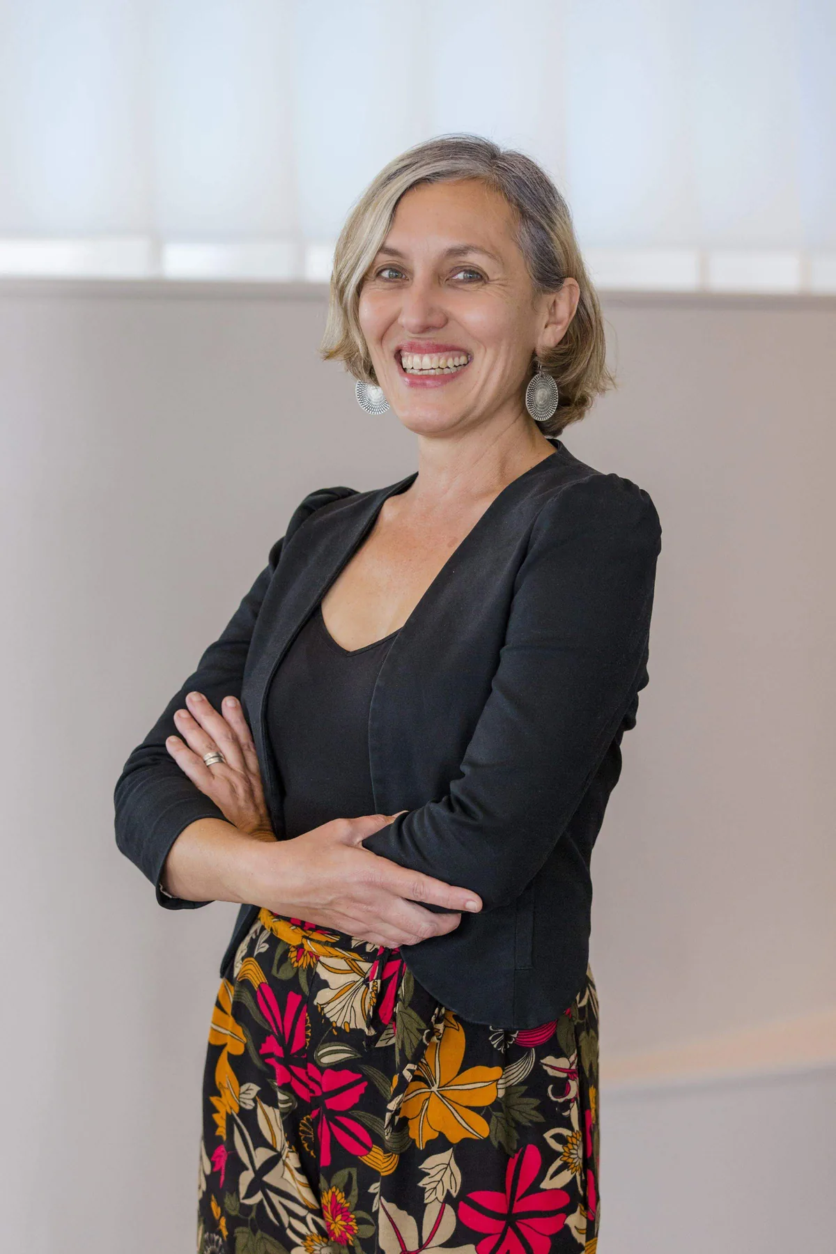 Leonie Sanderson standing with her arms folded in a bright room, photographed at a Health Consumers Queensland event in Cairns.