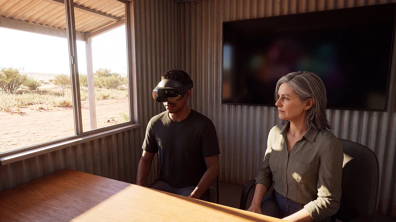 A simulated learning centre in a remote town, a window onto dry scrub. A student wears the headset at the desk as a tutor sits beside him, not behind.