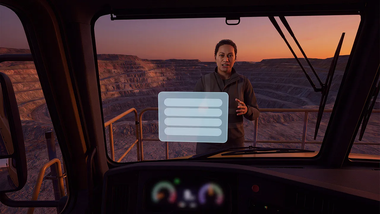 Inside the simulation: a trainer talks through the window of a haul truck cab, seen from the operator's seat, a terraced pit and orange sky at dusk beyond the windscreen.
